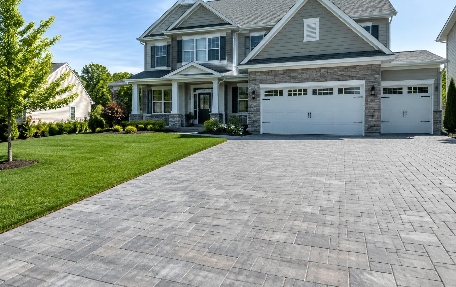 Finished paver driveway in front of a suburban home